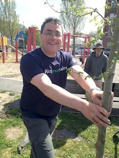 Man Smiling and Planting Trees